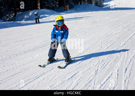 Cute little boy, skiing happily in Austrian ski resort in the mountains, wintertime Stock Photo