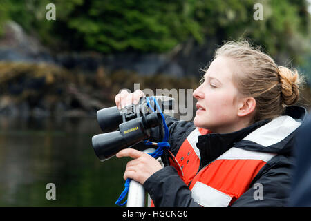 Crew with binoculars on cruise ship Safari Endeavour at anchor at Fords Terror, Endicott Arm, Tongass National Forest, Juneau, Alaska, USA. Cliff-wall Stock Photo