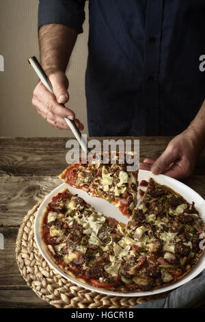 Pizza and a slice of pizza on a white dish vertical Stock Photo