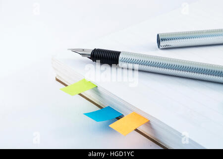 Fountain pen on white notebook with colorful stickers Stock Photo