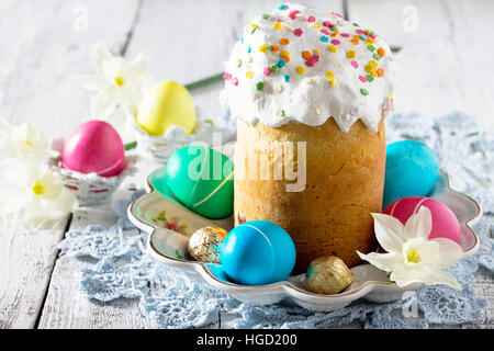 The traditional Easter treats: cakes and colorful easter eggs on a wooden table. Copy space. Stock Photo
