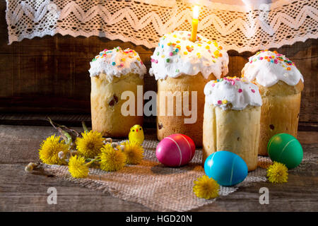 The traditional Easter treats: cakes and colorful easter eggs on a table in a rustic style. Copy space. Stock Photo