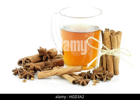 A glass of tea with cinnamon and star anise, on a white background. Stock Photo