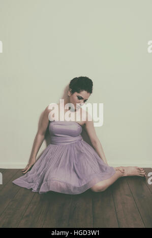 Sad woman sat on the floor Stock Photo