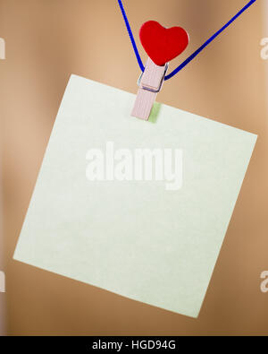 Heart clothes peg holding note with blank copy space Stock Photo