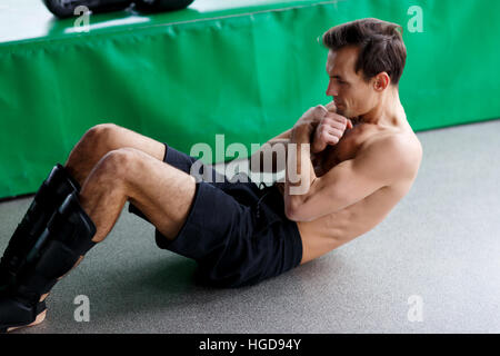 Young athlete shakes abdominal muscles Stock Photo