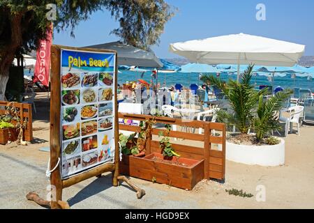 Palm Beach restaurant menu board on the edge of the beach with views towards the Aegean sea, Kalyves, Crete, Greece, Europe. Stock Photo