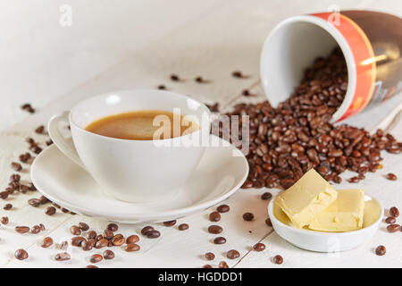 Bulletproof coffee with butter and beans on white table Stock Photo