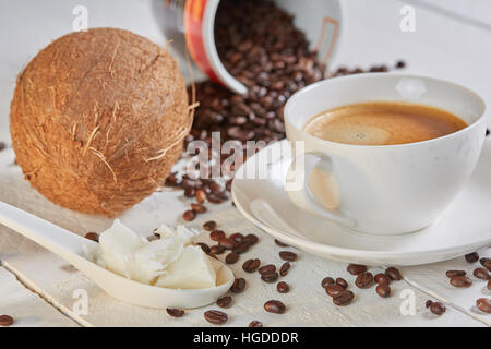 Coffee beans and coconut on white table for bulletproof coffee Stock Photo