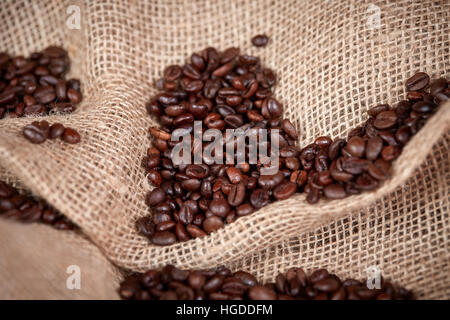 Black coffee beans on brown jute bag as background Stock Photo