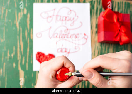 Man writing a Valentines day card and preparing a present Stock Photo