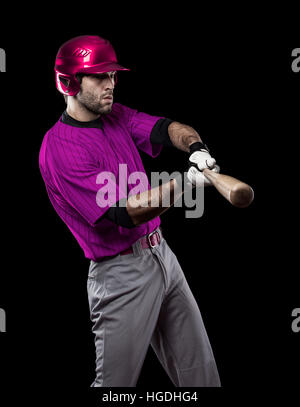 Baseball Player with a pink uniform on a black background. Stock Photo