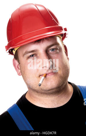 Mechanic wearing red construction helmet, cigarette in his mouth Stock Photo