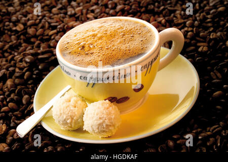 Cup of coffee atop a bed of coffee beans Stock Photo