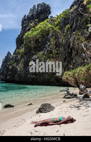 Young woman sunbathing remote beach Bacuit Archipelago Palawan Philippines Stock Photo