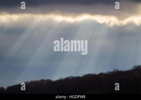 The sun's rays make their way through clouds on Stock Photo