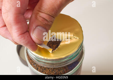 Man opening a new jar of coffee Stock Photo