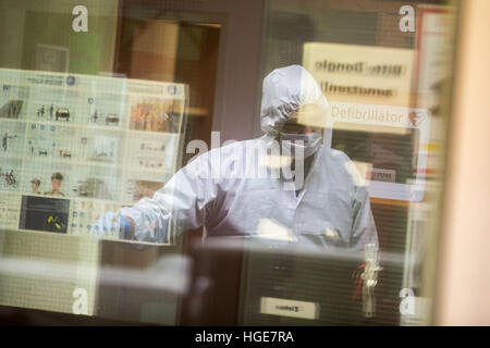 Duisburg, Germany. 08th Jan, 2017. A member of the criminal investigation squad securing traces at the entrance to the Rheinhausen police station in Duisburg, Germany, 08 January 2017. At the station earlier police shot dead a man armed with a knife. According to the state prosecutor's office, a middle-aged man entered the station in Rheinhausen shortly before midnight on Saturday, pulled a knife and was subsequently killed by several shots from a police weapon. Photo: Christoph Reichwein/dpa/Alamy Live News Stock Photo