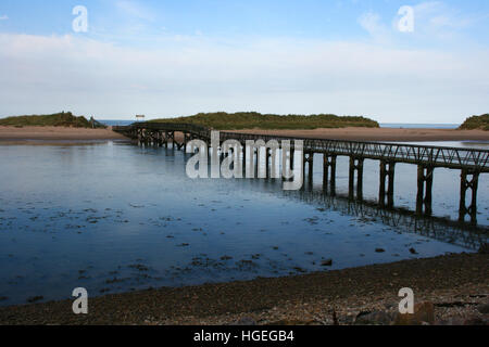 Wooden footbridge over a small sea water inlet separating the mainlaind at Kinloss Scotland from a small sand bar island