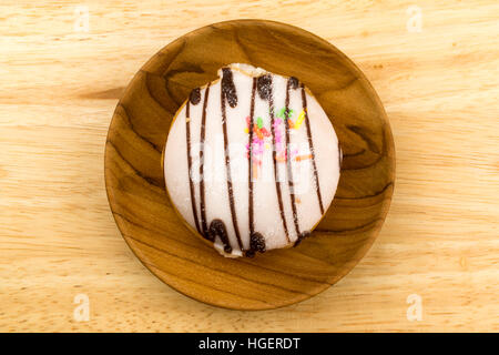 Delicious doughnut in a wooden plate on wooden board Stock Photo