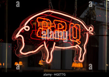 Red BBQ neon restaurant cafe sign in the shape of a pig Stock Photo