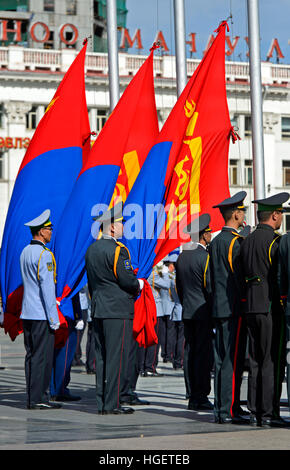 Officers of the Mongolian armee with the national flag during a flag ceremony on Sukhbaatar Square, Ulaanbaatar, Mongolia Stock Photo