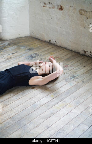 Sad girl laying down on the floor Stock Photo - Alamy