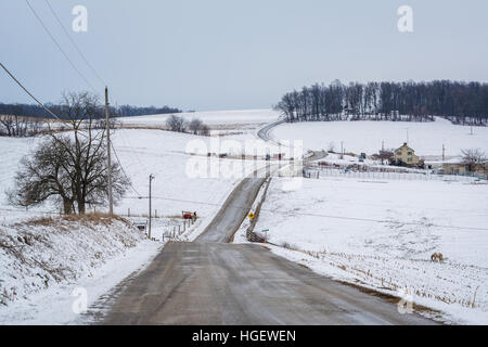 Road and view of snow covered farms and rolling hills, near Jefferson, Pennsylvania. Stock Photo