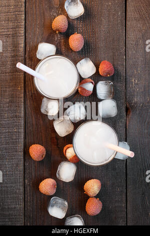 Two glasses of cold lychee juice on the old wooden table Stock Photo