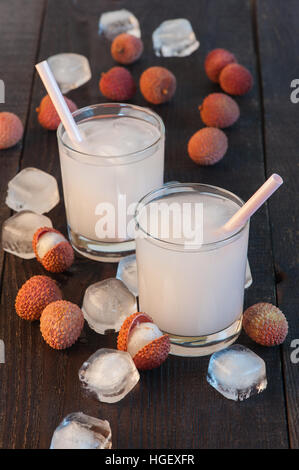 Two glasses of cold lychee juice on the old wooden table Stock Photo