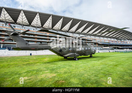 A Royal Navy Merlin helicopter sitting on the lawn in front of the grandstand at Royal Ascot Racecourse. Space for copy