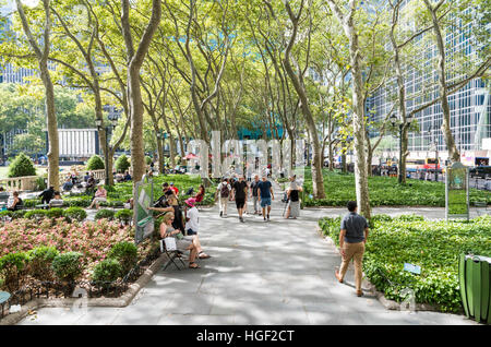 Tree lined path with people walking and sitting in Bryant Park, New York, in Summer. Stock Photo