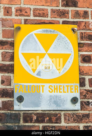 Yellow nuclear radioactive fallout shelter sign on a brick wall, USA Stock Photo