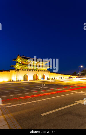 Long exposure car lights leaving trailing streak in front of Gwanghwamun main gate to historic Gyeongbokgung Palace at dusk in d Stock Photo