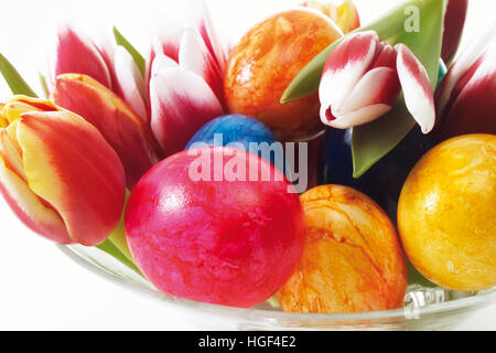 Glass bowl with painted Easter eggs and tulips Stock Photo