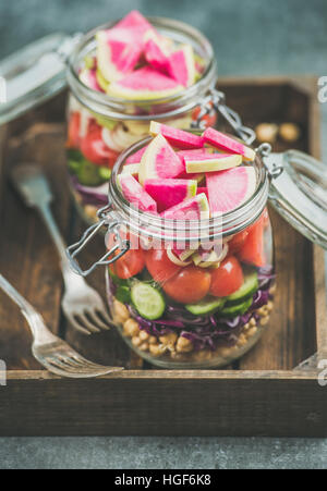 Close-up of healthy vegetarian salad in jars in wooden tray Stock Photo