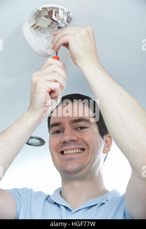 Man Installing Smoke Or Carbon Monoxide Detector Stock Photo