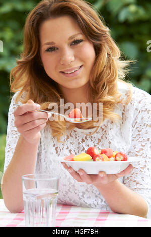 Teenage Girl Eating Healthy Bowl Of Fruit Salad Stock Photo