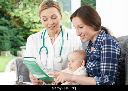 Health Visitor Giving Mother Leaflet With Advice On Baby Stock Photo