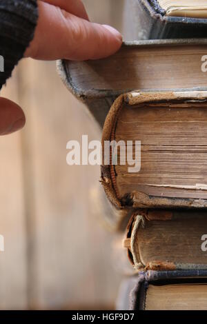 student or scientist takes the book on a shelf in the library, soft focus Stock Photo