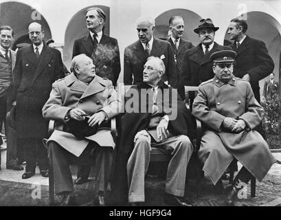 Winston Churchill, President FD Roosevelt and Joseph Stalin at the Yalta Conference, Crimea. Behind them are Anthony Eden and Molotov, February 1945. Stock Photo