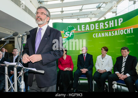 Gerry Adams gives a speech, with a backdrop saying 'Leadership Ceannasaíocht' Stock Photo