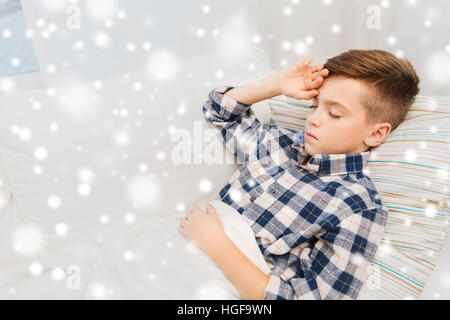 ill boy lying in bed and suffering from headache Stock Photo