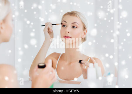 woman with makeup brush and eyeshade at bathroom Stock Photo