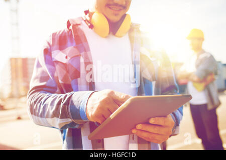 close up of builder with headphones and tablet pc Stock Photo