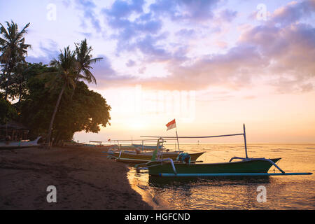 beautiful beach in Bali at sunset, exotic landscape with boats and palm trees Stock Photo