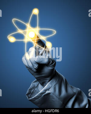 Researcher or scientist with rubber glove holding glowing atom model on blue background Stock Photo