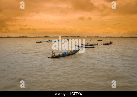 Sunderban, Bangladesh - circa July 2012: Photo of native people in wooden boats on river and fishing in Sunderban, Bangladesh. Documentary editorial. Stock Photo