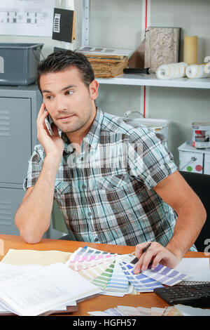man on telephone holding colour charts Stock Photo