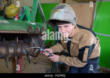 happy apprentice welder at work in the plant Stock Photo